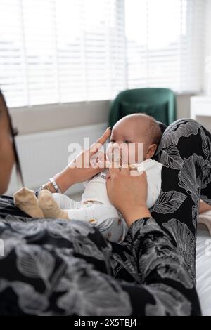 Frau, die dem neugeborenen Baby zu Hause einen Schnuller gibt Stockfoto