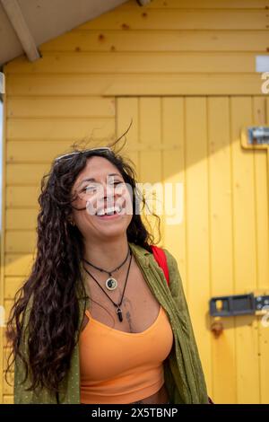 Lächelnde mittelerwachsene Frau in Sommerkleidung Stockfoto