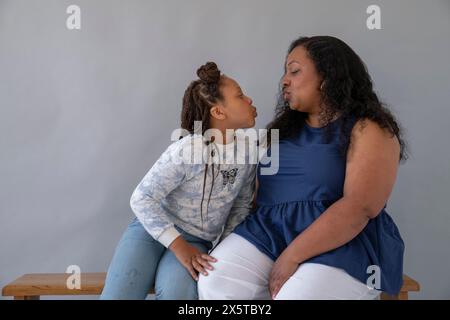 Mutter und Tochter (6-7), die sich anschauen und zerwürren Stockfoto