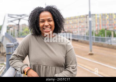 Porträt einer jungen Frau, die auf der Straße lächelt Stockfoto