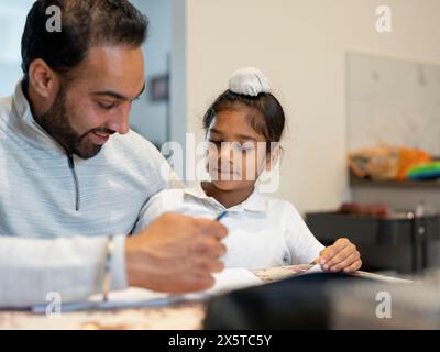 Vater hilft Sohn (6-7) bei Hausaufgaben Stockfoto