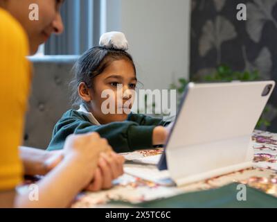 Mutter, die den Sohn (6-7) mit dem digitalen Tablet anbietet Stockfoto