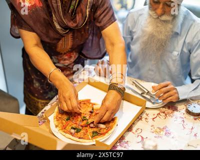 Seniorenpaar essen Pizza zu Hause Stockfoto
