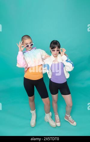 Studio-Porträt von zwei lächelnden Mädchen mit Sonnenbrille Stockfoto