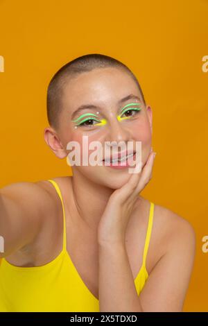 Studio-Porträt eines lächelnden Mädchens mit neonfarbenem Make-up Stockfoto