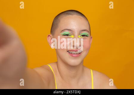 Studio-Porträt eines lächelnden Mädchens mit neonfarbenem Make-up Stockfoto