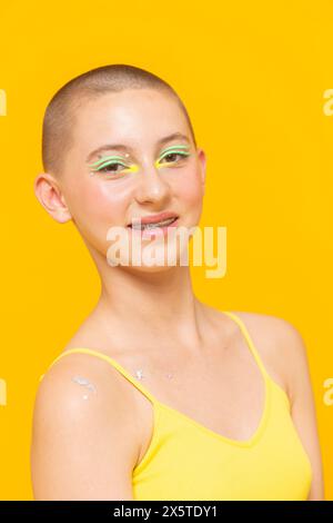 Studio-Porträt eines lächelnden Mädchens mit neonfarbenem Make-up und Sternen auf der Schulter Stockfoto