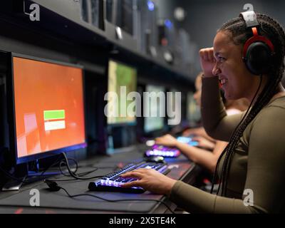 Junge Frau, die Videospiele im Spielclub spielt Stockfoto