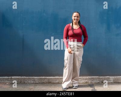 Portrait von lächelnden Frau gegen blaue Wand Stockfoto