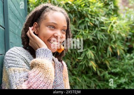 Porträt einer jungen Frau, die wegschaut, während sie im Garten steht Stockfoto