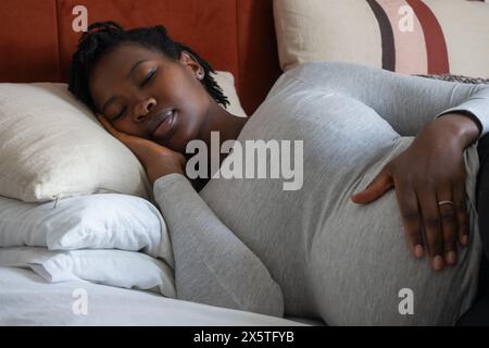 Schwangere Frau auf Bett schlafen Stockfoto