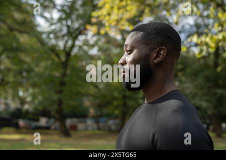 Profil eines Sportmannes, der im Park steht Stockfoto