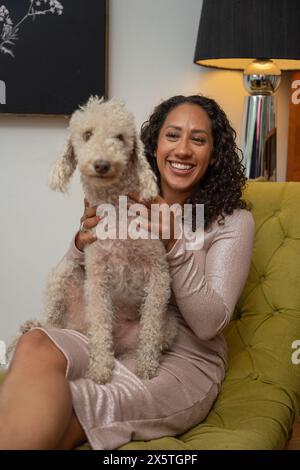 Frau sitzt mit bedlington Terrier auf ihrem Schoß Stockfoto