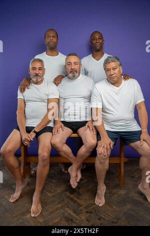 Porträt ernster Senioren vor violettem Hintergrund Stockfoto