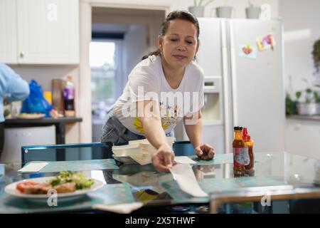 Frau bereitet Esstisch für das Mittagessen vor Stockfoto