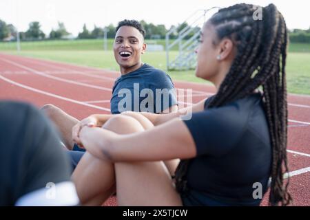 Ein paar Athleten, die sich nach dem Training auf der Sportbahn ausruhen Stockfoto