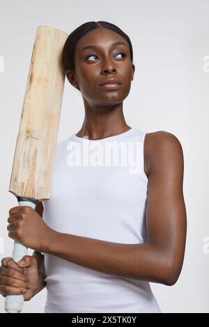 Studio-Porträt einer Sportfrau mit Cricketschläger Stockfoto