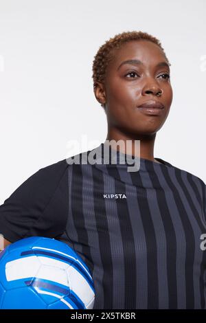 Studio-Porträt einer Fußballspielerin mit Ball Stockfoto