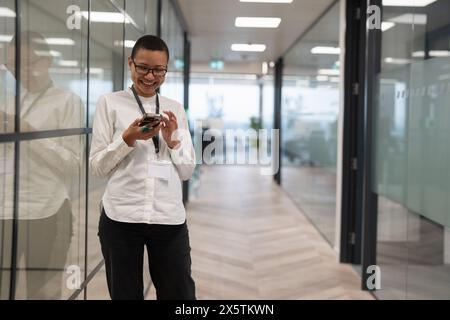 Nicht binärer Büroangestellter, der auf dem Flur steht Stockfoto