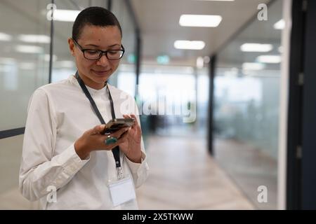 Nicht binärer Büroangestellter, der auf dem Flur steht Stockfoto