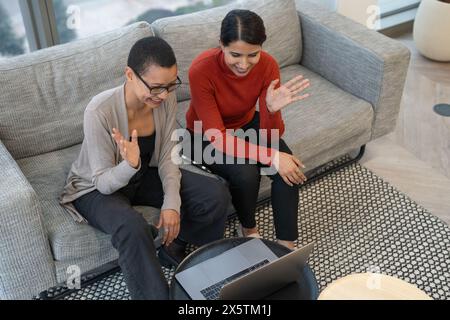 Kollegen, die Online-Meetings in der Lobby des Büros durchführen Stockfoto