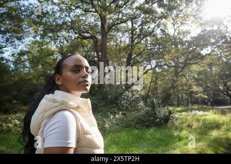 Porträt einer jungen Frau, die sich am sonnigen Tag im Park erholt Stockfoto