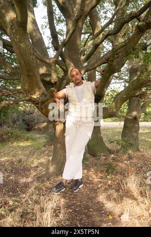 Porträt der jungen Frau am Baum gelehnt Stockfoto
