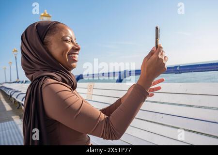 Muslimische Frau fotografiert den Blick mit dem Smartphone an sonnigen Tagen Stockfoto