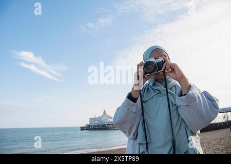 Porträt einer muslimischen Frau, die mit einer analogen Kamera fotografiert Stockfoto