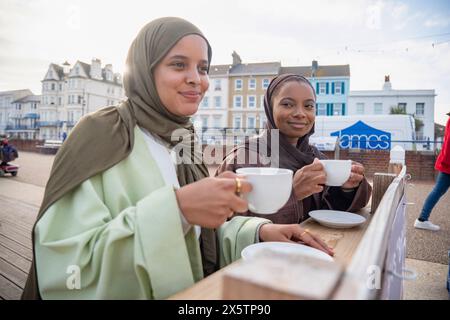 Zwei muslimische Frauen trinken Kaffee im Straßencafé Stockfoto