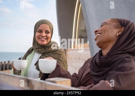 Zwei muslimische Frauen trinken Kaffee im Straßencafé Stockfoto