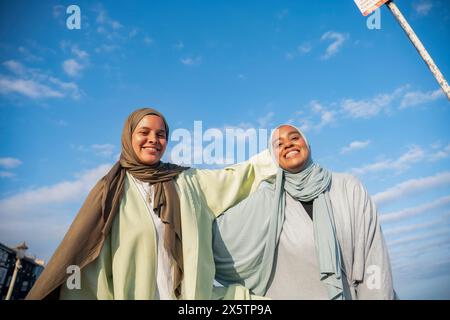 Porträt lächelnder muslimischer Frauen, die an sonnigen Tagen in die Kamera schauen Stockfoto