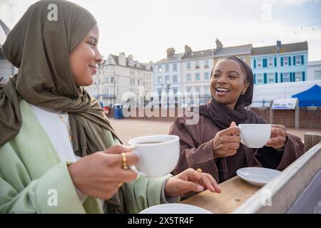 Zwei muslimische Frauen trinken Kaffee im Straßencafé Stockfoto