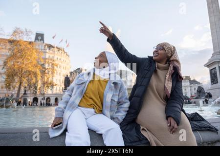 Großbritannien, London, Junge weibliche Touristen in Hijabs, die sich am Marktplatz der Stadt entspannen Stockfoto