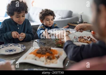 Familie mit Söhnen (2-3, 6-7), die zu Hause essen Stockfoto