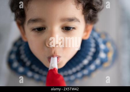 Junge (2-3) bläst Partyhorngebläse Stockfoto