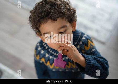 Junge (2-3) bläst Partyhorngebläse Stockfoto