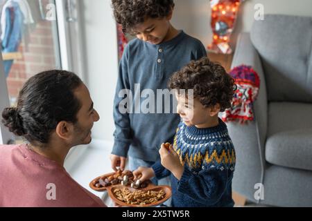 Vater und Söhne (2-3, 6-7) teilen sich Nahrung Stockfoto