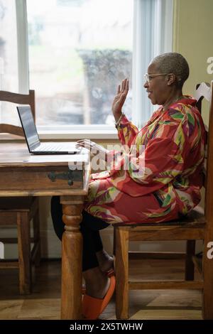 Reife Frau mit Laptop zu Hause Stockfoto