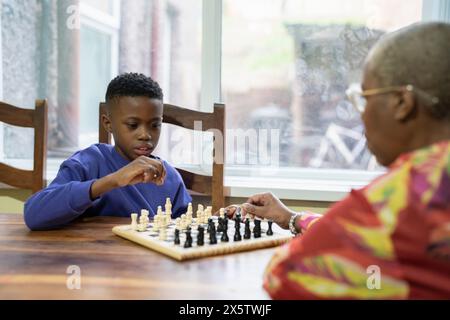 Großmutter und Enkel spielen zu Hause Schach Stockfoto