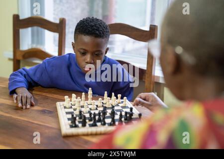 Großmutter und Enkel spielen zu Hause Schach Stockfoto