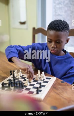 Junge spielt Schach zu Hause Stockfoto