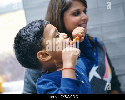 Mutter und Sohn putzen im Badezimmer Stockfoto