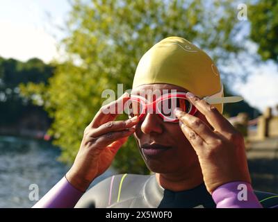 Eine Frau, die Schwimmbrille anzieht Stockfoto