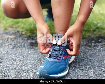 Frau bindet Laufschuhschnürsenkel Stockfoto