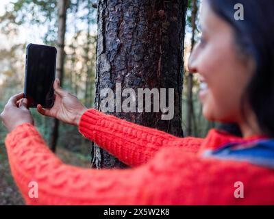 Lächelnde Wanderer, die Selfie im Wald macht Stockfoto