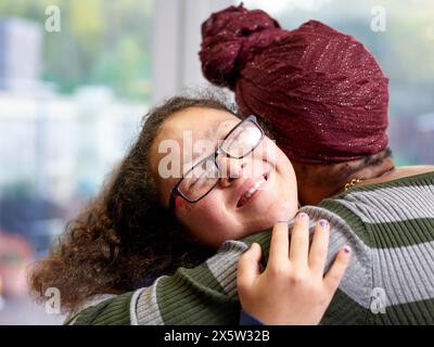 Mutter und Tochter mit Down-Syndrom-Umarmungen Stockfoto