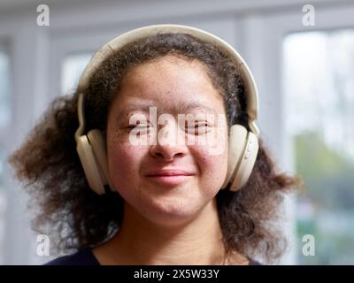 Mädchen mit Down-Syndrom, das Kopfhörer trägt Stockfoto