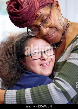 Mutter und Tochter mit Down-Syndrom-Umarmungen Stockfoto