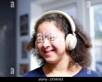 Mädchen mit Down-Syndrom, das Kopfhörer trägt Stockfoto